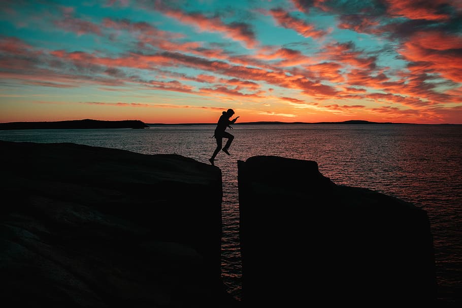 foto di silhouette, l'uomo salta, scogliera, mare, tramonto, persona, salto, saltare, gola, Cloudscape, nube, cielo, orizzonte, silhouette, Esplorare, avventura, natura, oceano, salto della fede, acqua, scenics - natura, bellezza nella natura, una persona, in piedi, stili di vita, attività di svago, persone reali, la tranquillità, scena tranquilla, colore arancione, nuvola - cielo, spiaggia, terra, orizzonte sull'acqua, all'aperto, braccio umano, braccia alzate, 5K