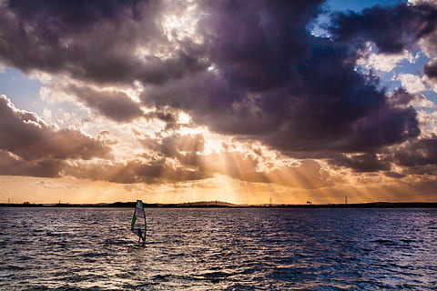person windsurfing, gylden, time, solstråler, himmel, skyer, solnedgang, windsurfing, vann, hav, sky - himmel, én person, skjønnhet i naturen, naturskjønnhet - natur, sport, horisont, natur, silhouette, horisont over vann, fritidsaktivitet, vannkanten, livsstil, sollys, ekte folk, utendørs, 1080P, CC0, offentlig domene, opphavsrett gratis