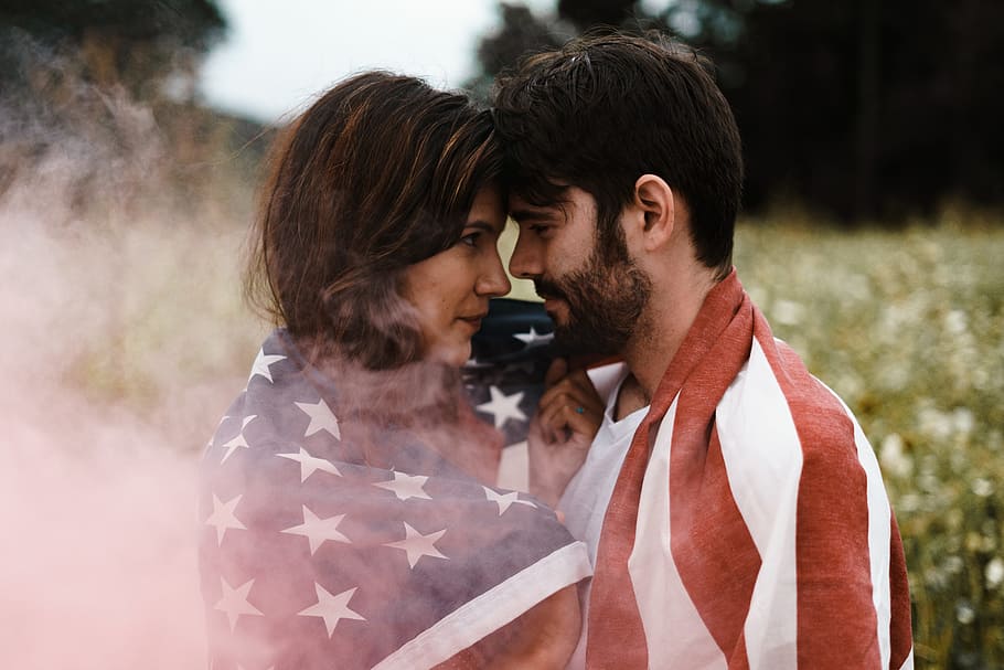 home, de peu, frontal, dona, cobert, u.s.a., bandera, selectiu, fotografia, cara de dona, home i dona, cara a cara, u.s.a. bandera, homes, a l'aire lliure, adult, dones, parella heterosexual, només adults, dues persones, ètnia caucàsica, tècnica de la imatge, somrient, tipus d’imatge, hora del dia, dia, home jove, ètnia, amor, activitat en moviment, edat humana, dones joves, gent, imatge en color, celebració, parella - relació, relació humana, naturalesa, mascles, forma de comunicació, punt de vista, estils de vida, unió, cabell castany, emoció positiva, emoció, adult jove, romanç, connexió, petons, parella jove, 5K