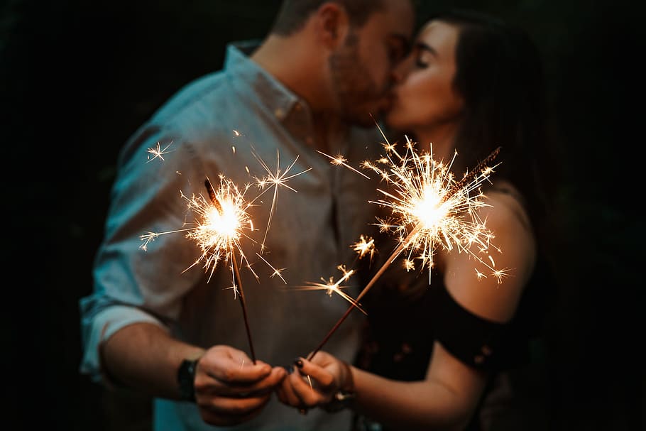 Mann, Frau, küssen, halten, Feuerwerk bei schlechten Lichtverhältnissen, Funke, Feuerwerkskörper, Mann und Frau, Feier, Wunderkerze, Feuer - natürliches Phänomen, Menschen, Flamme, Männer, Glück, Verbrennung, Feuerwerk - künstliches Objekt, Nacht-, heiter, Erwachsene, Kerze, menschliche Hand, Zusammengehörigkeit, Bewegung, beleuchtet, zwei Menschen, glühend, Funken, Bewegungsunschärfe, Kunst, Kultur und Unterhaltung, Veranstaltung, junger Erwachsener, Feuerwerk, junge Frau, Hand, Paar - Beziehung, positive Emotionen, dunkel, 2K
