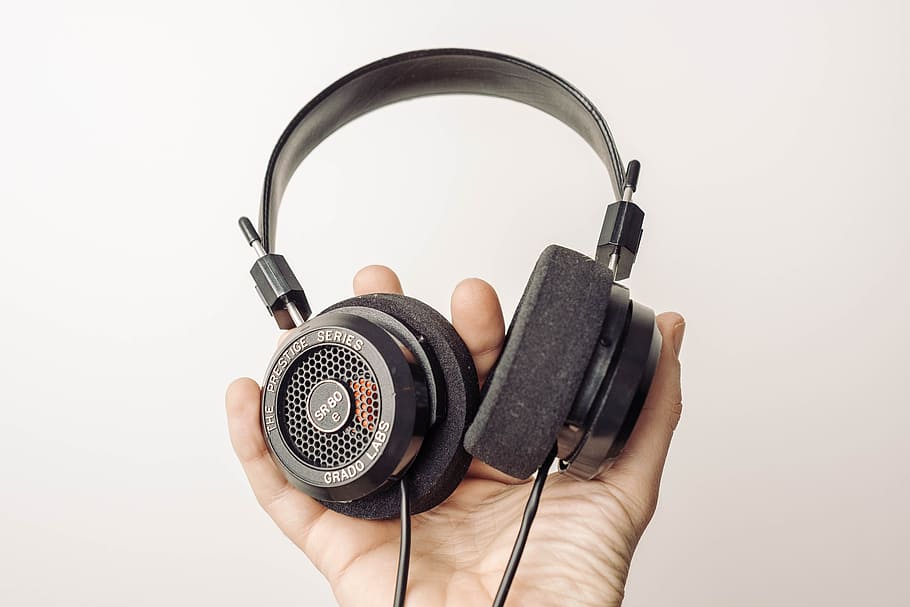 persona, detenzione, nero, cuffie over-ear, con filo, cuffie, mano, tecnologia, auricolare, ascoltando, suono, musica, attrezzatura, singolo oggetto, equipaggiamento audio, isolato, parte del corpo umano, mano umana, una persona, girato in studio, in casa, sfondo bianco, ritagliare, parte del corpo, stili di vita, prospettiva personale, persone reali, adulto, uomini, volto oscurato, 5K