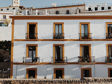 persona, de peu, balcó, bicicleta, blanc, marró, concret, edifici, arquitectura, pedra, amagat, estructura construïda, exterior de l'edifici, finestra, cap gent, ciutat, barri residencial, dia, llum solar, naturalesa, a l'aire lliure, costat a costat, marc complet, vista d’angle baix, fons, apartament, en fila, cel, 4K, CC0, domini públic, lliure de regalies
