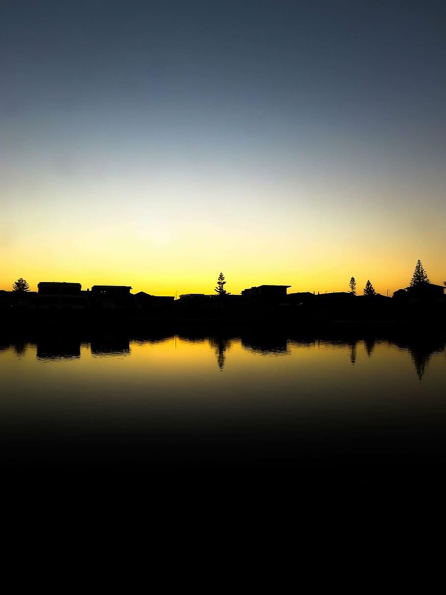 silueta, cases, arbres, cos, aigua, edificis, blau, cel, posta de sol, fosc, reflexió, arbre, planta, cap gent, vespre, a l'aire lliure, escenics, escena tranquil·la, llac, tranquil·litat, escenics - natura, bellesa a la natura, naturalesa, davant del mar, còpia espai, idíl·lic, color taronja, aigua estancada, exterior de l'edifici, 5K