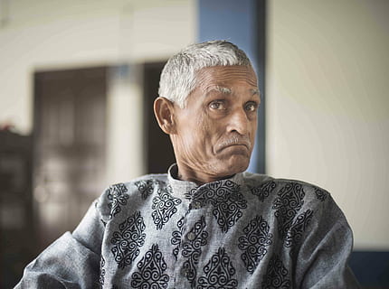 mand, indien, ekspression, kun mænd, kun en mand, kun voksne, en person, gråt hår, hovedskud, kun en moden mand, mennesker, moden voksen, voksen, portræt, senior voksen, forfra, kigger på kameraet, fokus på forgrunden, hanner, modne mænd, sweater, herrer, rigtige mennesker, indendørs, dag, leder, overvejelse, 5K