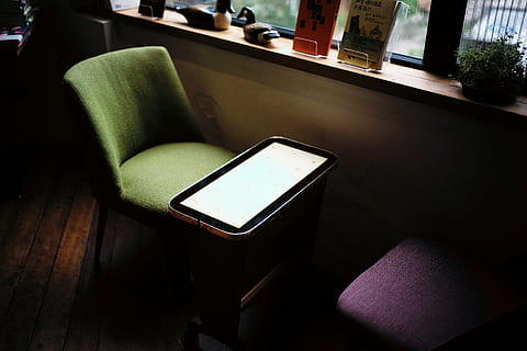 grøn, stol, foran, bord, vindue, smartphone på sofaen, kaffebar, indendørs, ingen mennesker, sæde, moderne, tom, møbel, teknologi, enhed skærmen, hjem interiør, hjemlige værelse, sofa, fravær, træ - materiale, høj vinkel visning, fokus på forgrunden, stilleben, forretning, dag, stue, lænestol, 5K, CC0, offentligt domæne, royaltyfrie