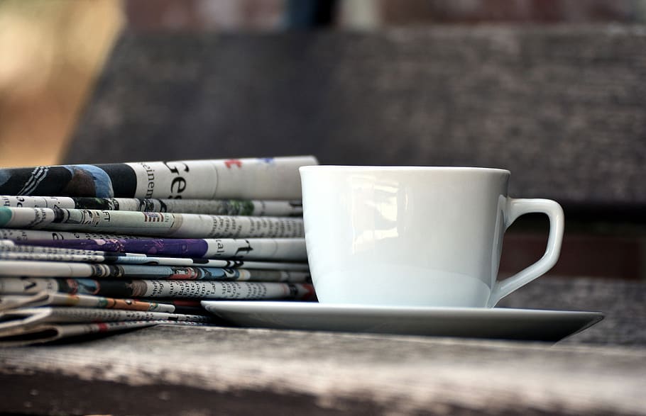 bianca, ceramica, tazza di tè, piattino, tazza, giornali, riviste, pila di carta, stampa, informazione, tazza di caffè, leggere, rompere, notizia, rilassare, il tempo di accadere, leggere il giornale, formazione scolastica, conoscere, bere, boccale, cibo e bevande, rinfresco, nessuno, caffè, caffè - bevanda, tavolo, messa a fuoco selettiva, avvicinamento, bevanda calda, pubblicazione, libro, in casa, giorno, concentrarsi sulle conoscenze acquisite, comunicazione, attività commerciale, vasellame, 5K