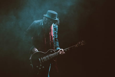 Person, tragen, Anzugjacke, Fedorahut, spielen, Gitarre, Musik-, Musiker, Gitarrist, Rockmusik, Musikinstrument, elektrische Gitarre, Menschen, Kunst und Unterhaltung, eine Person, Männer, Performance, Popmusiker, Künstler, dunkel, Veranstaltung für darstellende Künste, Konzert der populären Musik, Bühne - Aufführungsraum, Unterhaltung, Nur ein Mann, Nur Männer, Rauch - physische Struktur, Kunst, Kultur und Unterhaltung, Saiteninstrument, Musikausrüstung, Bühne, Veranstaltung, moderner Rock, ein Instrument zupfen, Nachtleben, schwarzer Hintergrund, Mikrofonständer, Konzert, 5K, CC0, gemeinfrei, lizenzfrei