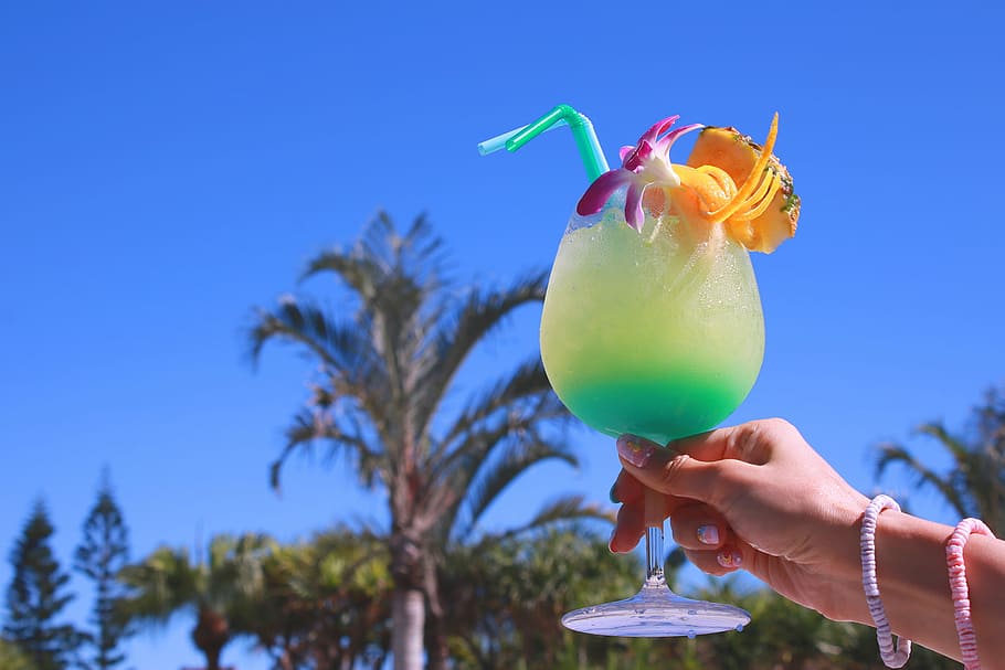 Person, halten, Gelb, Petrol, Flüssigkeit, gefüllt, Glas mit Füßen, klar, Blau, Himmel, Glas, Sommer-, draußen, Strand, Urlaube, Cocktail, tropisches Klima, Natur, Palme, Obst, Spaß, menschliche Hand, menschliches Körperteil, Essen und Trinken, Lebensmittel, Getränk, Hand, Erfrischung, Alkohol, Frische, Pflanze, eine Person, Trinkglas, tropisches Getränk, 1080P
