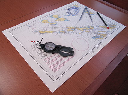 map, compass, navigation, high angle view, paper, indoors, direction, still life, no people, table, guidance, travel, text, planning, document, world map, communication, publication, wood - material, navigational equipment, navigational compass, 2K, CC0, public domain, royalty free