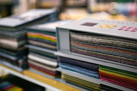 design material samples, Album, design, material, samples, fabric, cloth, colour, sample, book, stack, library, literature, multi colored, choice, variation, store, no people, indoors, publication, selective focus, large group of objects, close-up, focus on foreground, in a row, paper, shelf, arrangement, still life, order, 2K