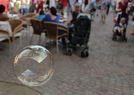soap bubble, floating, bubble, reflections, air, summer, lightweight, street, incidental people, city, focus on foreground, group of people, day, outdoors, business, seat, architecture, chair, table, transparent, reflection, men, real people, cobblestone, paving stone, sphere, nature, 2K, CC0, public domain, royalty free