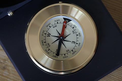 silver compass, compass, north, compass point, navigation, navigate, show, points of the compass, direction, windrose, directory, needle, orient, orientation, equipment, number, guidance, circle, accuracy, geometric shape, close-up, shape, no people, indoors, navigational compass, single object, instrument of measurement, time, high angle view, clock, navigational equipment, text, meteorology, clock face, positioning, 5K, CC0, public domain, royalty free