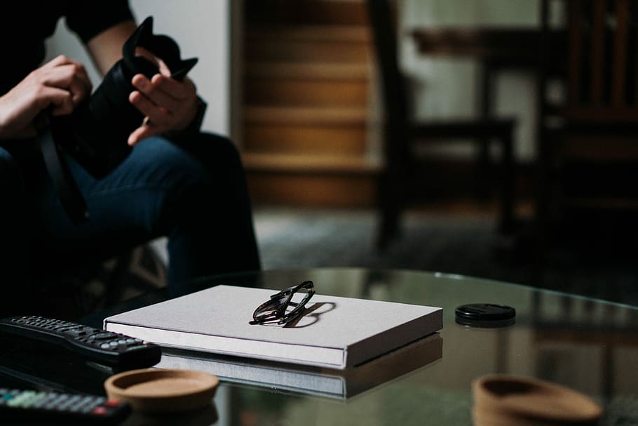 Brille, oben, Weiß, Buch, Person, halten, DSLR-Kamera, Vorderseite, Glastisch, Kaffetisch, Tabelle, Notizbuch, Notizblock, Lebensstil Fotografie, Lebensstil, Fotografie, Kamera, Glas, warm, launisch, Fernbedienung, Steuerung, Kameraausrüstung, Fotograf, Tiefenschärfe, Fokus, Technologie, kabellose Technologie, Kommunikation, eine Person, drinnen, Mobiltelefon, Erwachsene, Veröffentlichung, Telefon, Verbindung, Sitzung, Fokus auf den Vordergrund, Papier-, Pistole, Aktivität, Dreiviertel Länge, 5K