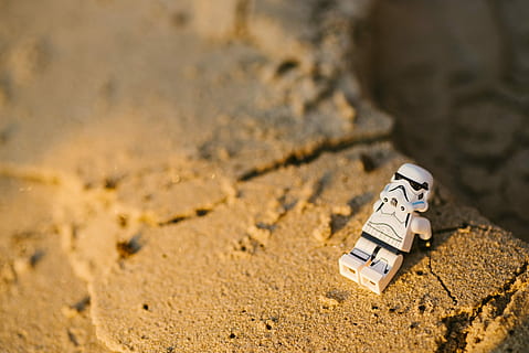 selectiu, focalitzar la fotografia, star wars stormtrooper minifigure, sorra, xifra de troopas, marró, pedra, paret, platja, lego, terra, cap gent, dia, centrar-se en primer pla, naturalesa, brutícia, a l'aire lliure, llum solar, vista d’angle alt, primer pla, enfocament selectiu, joguina, absència, descobriment, comunicació, animal, 5K, CC0, domini públic, lliure de regalies
