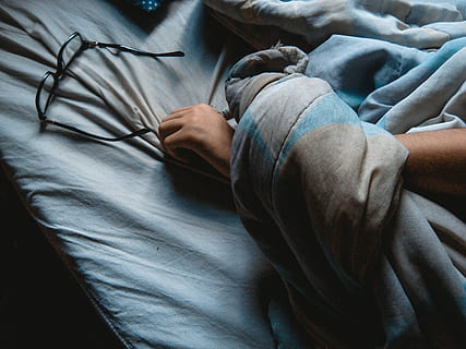 black, framed, eyeglasses, blue, bedsheet, frames, gray, textile, bed, sheets, glasses, hand, glass, one person, real people, human hand, midsection, human body part, indoors, furniture, casual clothing, lifestyles, men, high angle view, day, adult, holding, clothing, front view, finger, 2K, CC0, public domain, royalty free