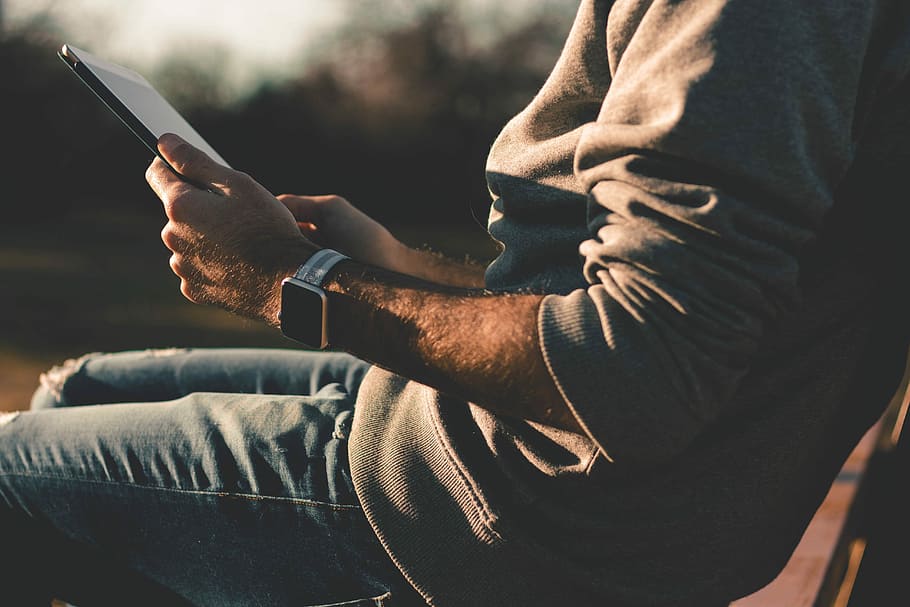 persona, assegut, cadira, utilitzant, tauleta, celebració, ipad, rellotge de poma, tecnologia, mans, texans, secció mitjana, comunicació, una persona, tecnologia sense fils, homes, roba casual, estils de vida, adult, activitat d'oci, centrar-se en primer pla, persones reals, connexió, primer pla, dia, telèfon mòbil, mascles, mà, 5K