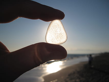 persona, celebració, blanc, pedres precioses, sol, pedra, ombra, mà, llum de fons, permeable, vidre, sablat, dit, mantenir, platja, mar, mà humana, part del cos humà, una persona, aigua, naturalesa, cel, terra, adult, primer pla, part del cos, a l'aire lliure, llum solar, dit humà, 2K, CC0, domini públic, lliure de regalies