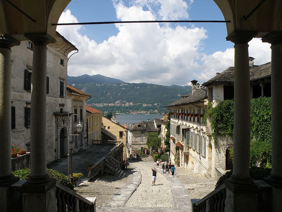 Italia, cielo, nubes, arco, arqueado, edificios, urbano, arquitectura, montañas, bosque, arboles, calle, acera, fuera de, verano, primavera, las flores, estructura construida, exterior del edificio, edificio, nube - cielo, montaña, ciudad, personas incidentales, día, naturaleza, grupo de personas, adulto, Distrito residencial, hombres, mujer, pueblo, gente real, gente, viaje, columna arquitectonica, al aire libre, paisaje urbano, 2K