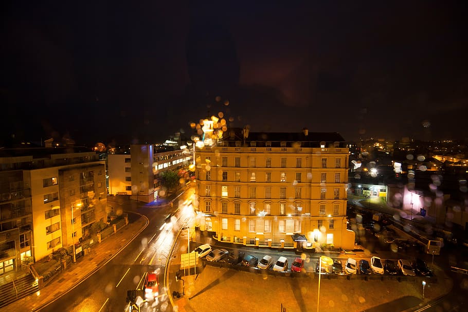 déšť, reflexy, spojení, hotel, obytných budov, kancelářská budova, provoz, architektura, budova, Anglie, soumrak, svítí, město, fasáda, obsazení, oranžový, parkoviště, auta, noc, stavba, exteriér budovy, přeprava, pouliční osvětlení, auto, silnice, způsob dopravy, motorové vozidlo, ulice, vysoký úhel pohledu, pozemního vozidla, pohyb, městský život, náhodné osoby, venku, noční život, 5K