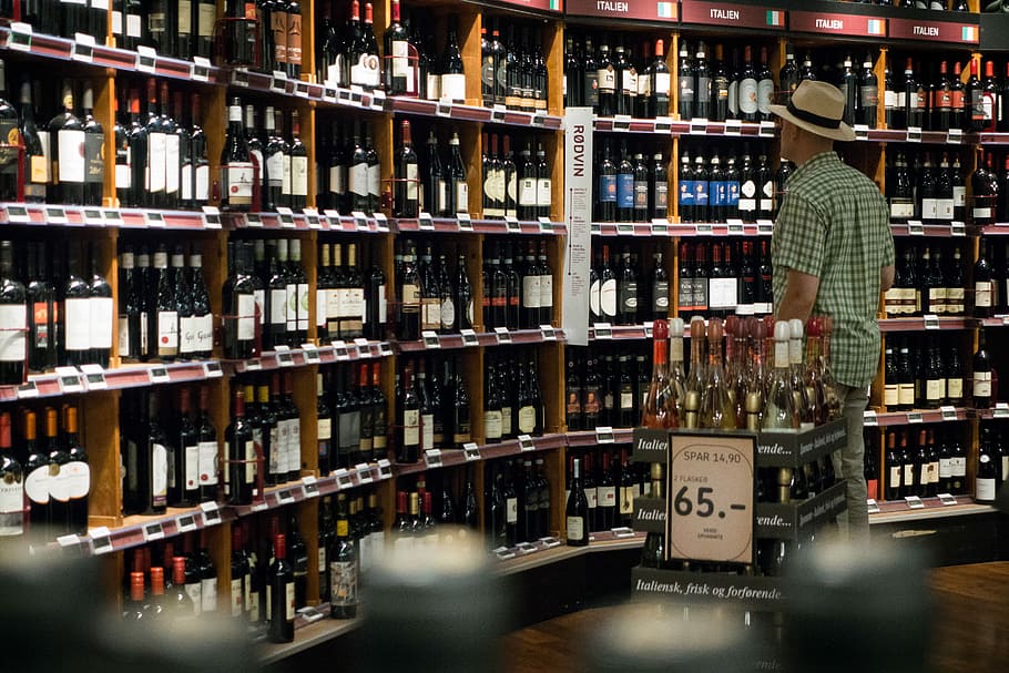 choosing, wine, wine store, Man, drink, store, shelf, indoors, alcohol, bottle, wine Bottle, in A Row, retail, color Image, large Group of Objects, one person, abundance, food and drink, container, refreshment, choice, adult, standing, variation, arrangement, order, liquor store, 5K