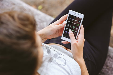 young, woman, holding, white, mobile, phone, mobile phone, caucasian, female, girl, tech, technology, hands, femine, white phone, smartphone, screentouch, women, adult, people, caucasian Ethnicity, one Person, lifestyles, wireless Technology, females, human Hand, communication, sitting, connection, rear view, high angle view, smart phone, portable information device, two people, human body part, hand, telephone, casual clothing, outdoors, over the shoulder view, 4K