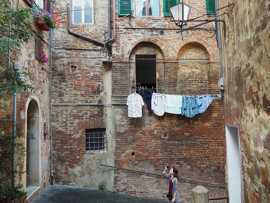 dona, gris, cardigan, celebració, càmera, presa, foto, floral, arranjament, 3r, Finestra de tres pisos, maó, residencial, edifici, durant el dia, arranjament floral, pis, finestra, edifici residencial, arquitectura, europa, exterior de l'edifici, Itàlia, carrer, estructura construïda, a l'aire lliure, escena urbana, vell, arquitectura i edificis, casa, façana, paret de maó, porta, arc, dia, barri residencial, paret, penjant, roba, estenedor, cap gent, funció de construcció de parets, estils de vida, 4K