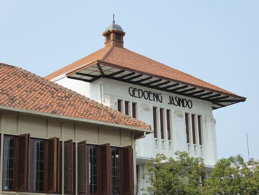 edifici gedoeng jasindo, batavia, jakarta, java, asia, viatjar, colonial, kota, arquitectura, estructura construïda, exterior de l'edifici, edifici, cel, cel clar, vista d’angle baix, dia, cap gent, naturalesa, sostre, religió, creença, lloc de culte, espiritualitat, planta, a l'aire lliure, arbre, text, ciutat, columna arquitectònica, teula de teulada, 4K