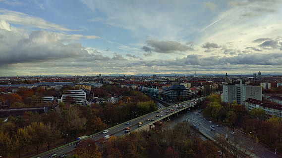 München, skyer, overskyet, bjerge, himmel, bayern, udsigt, vision, bybilledet, arkitektur, gade, urban scene, by, Trafik, Europa, by skyline, sky - himmel, bygget struktur, bygning udvendig, transportmidler, høj vinkel visning, vej, natur, ingen mennesker, bygning, transportform, boligområde, plante, bil, byliv, udendørs, multiple lane motorvej, 5K, CC0, offentligt domæne, royaltyfrie