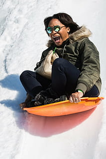 sne, slæde, sjovt, vinter, udendørs, mennesker, smilende, sport, fritidsaktiviteter, fritidsaktivitet, ferier, en person, sidder, rigtige mennesker, kold temperatur, livsstil, lykke, tøj, emotion, fuld længde, forfra, nydelse, ung voksen, varme tøj, munden åben, 1080P, CC0, offentligt domæne, royaltyfrie