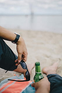 together, beach, sand, summer, man, blanket, holidays, vacations, male, beer, men, outdoors, bottle, people, sea, human Hand, adult, holding, alcohol, beer Bottle, beer - Alcohol, shoe, low section, human leg, human body part, real people, body part, lifestyles, focus on foreground, two people, day, leisure activity, land, personal perspective, hand, human foot, wristwatch, finger, human limb, jeans, shorts, 2K