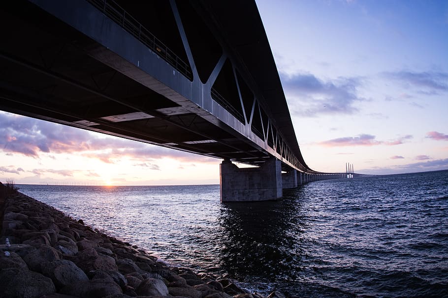 svart, bro, solnedgang, arkitektur, bukt, skyer, forbindelse, skumring, kveld, landskap, metall, utendørs, refleksjon, bergarter, hav, strandlinjen, himmel, stål, steiner, sol, vann, bygget struktur, sky - himmel, bro - menneskeskapte struktur, ingen folk, natur, naturskjønnhet - natur, transport, horisont over vann, skjønnhet i naturen, horisont, vannkanten, arkitektonisk kolonne, under, 5K