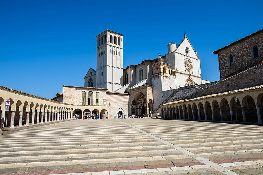 fotografia d'angle baix, marró, catedral, assisi, aziz, quadrat, monestir, arquitectura, estructura construïda, exterior de l'edifici, edifici, blau, lloc de culte, religió, creença, cel clar, cel, destinacions de viatge, història, el passat, naturalesa, ciutat, carrer, assolellat, a l'aire lliure, rellotge, 1080P