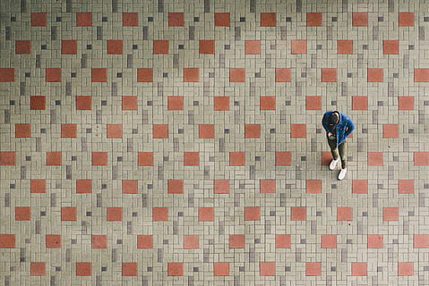 man, standing, brown, beige, ground, wearing, blue, jacket, holding, smartphone, floor, from above, pattern, male, full length, one person, high angle view, real people, men, flooring, lifestyles, leisure activity, indoors, architecture, rear view, casual clothing, walking, tile, built structure, day, adult, tiled floor, 2K, CC0, public domain, royalty free