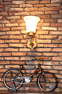 fiets, ontwerp, creativiteit, stenen muur, lamp, muur - bouwfunctie, muur, verlichtingsapparatuur, steen, vervoer, landvoertuig, geen mensen, wijze van transport, architectuur, verlicht, ingebouwde structuur, elektrische lamp, buitenkant van het gebouw, dag, stationair, straat, buitenshuis, lage hoekweergave, 2K, CC0, publiek domein, royaltyvrij