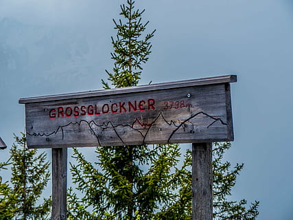 scudo, Grossglockner, montagne, nuvole, testo, comunicazione, sceneggiatura occidentale, albero, pianta, cartello, natura, nessuno, giorno, informazione, legno - materiale, cielo, all'aperto, Inquadratura dal basso, segno di informazione, crescita, lettera maiuscola, guida, sceneggiatura non occidentale, copione, 4K, CC0, dominio pubblico, privo di copyright