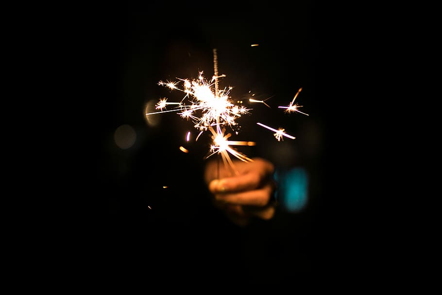 persona que sosté petard, persona, celebració, encès, sparkler, espurna, nit, verd blavós, taronja, mà, flama, focs artificials, estiu, quart, 4t, diversió, gra, juliol, llum, piscina, gelat, il·luminat, cultura i entreteniment artístic, moviment, esdeveniment, brillant, cremant, exhibició de focs artificials, focs artificials - objecte fet per l'home, mà humana, moviment borrós, exposició llarga, primer pla, part del cos humà, fosc, espurnes, fons negre, dit, 8K
