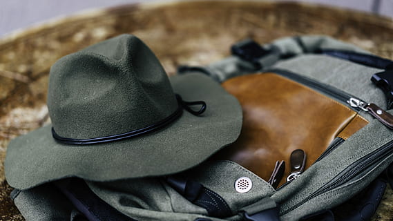 round hat, gray, bag, black, cowboy hat, brown, hat, backpack, clothing, close-up, indoors, no people, still life, security, high angle view, focus on foreground, studio shot, safety, textile, fashion, absence, protection, black color, simplicity, personal accessory, leather, 8K, CC0, public domain, royalty free