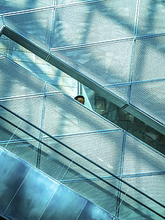 man, standing, beside, wall, building, architecture, infrastructure, elevator, shopping, mall, people, glass - Material, blue, modern, window, reflection, built structure, no people, indoors, day, low angle view, pattern, full frame, staircase, city, office, escalator, steps and staircases, ceiling, 4K, CC0, public domain, royalty free