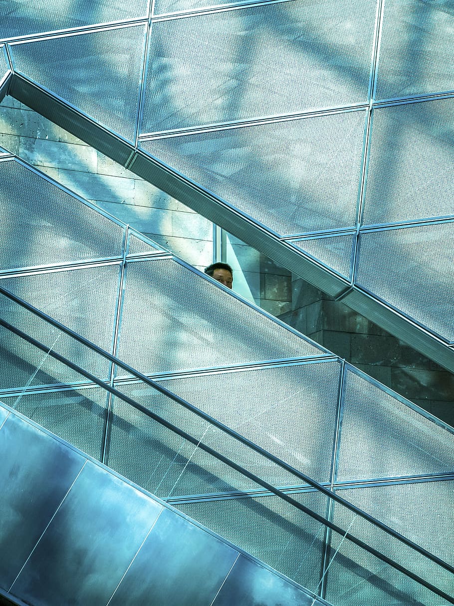 man, standing, beside, wall, building, architecture, infrastructure, elevator, shopping, mall, people, glass - Material, blue, modern, window, reflection, built structure, no people, indoors, day, low angle view, pattern, full frame, staircase, city, office, escalator, steps and staircases, ceiling, 4K