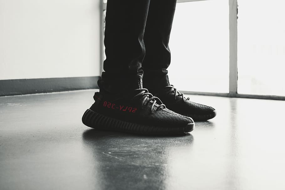 yeezy, parell, negre, adidas yeezy, estímul, 350 v 2, v2, sabata, entrenador, sabatilla d'esport, model, secció baixa, part del cos, cama humana, part del cos humà, a l'interior, una persona, de peu, sòls, estils de vida, persones reals, dia, peu humà, dones, membre, extremitat humana, primer pla, moda, 5K