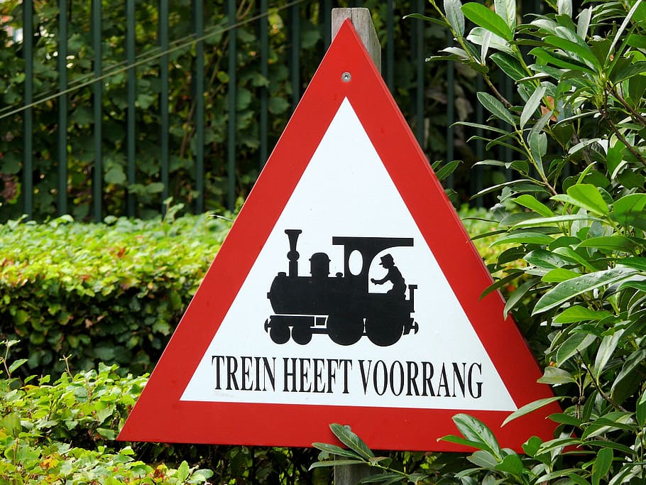 senyal d'advertència, tren, efteling, forma de triangle, perill, dia, a l'aire lliure, senyal de trànsit, comunicació, signe, planta, naturalesa, representació, informació, forma, vermell, text, signe d'informació, creixement, primer pla, cap gent, color verd, representació humana, 2K