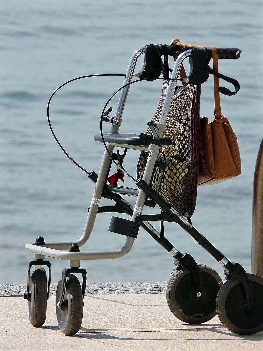 gris, negre, rotatiu, concret, paviment, cos, aigua, caminador, gent gran, mobilitat, rollator, anar, cames, dona vella, vell, coix, persona, pensionista, fràgil, problemes de mobilitat, lliscar, seguretat, cura, humà, correr, seniorin, edat, mar, a l'aire lliure, transport, vacances, estiu, platja, cistella, cap gent, dia, centrar-se en primer pla, naturalesa, manera de transport, terra, protecció, bellesa a la natura, cel, tranquil·litat, equipament, metall, 2K