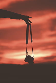 foto di silhouette, persona, detenzione, telecamera, tramonto, cielo, accessorio, fotografia, all'aperto, silhouette, nuvola - cielo, colore arancione, sospeso, persone reali, natura, una persona, stili di vita, concentrarsi sulle conoscenze acquisite, bellezza nella natura, esercizio, la tranquillità, scena tranquilla, persona irriconoscibile, braccia alzate, 4K, CC0, dominio pubblico, privo di copyright