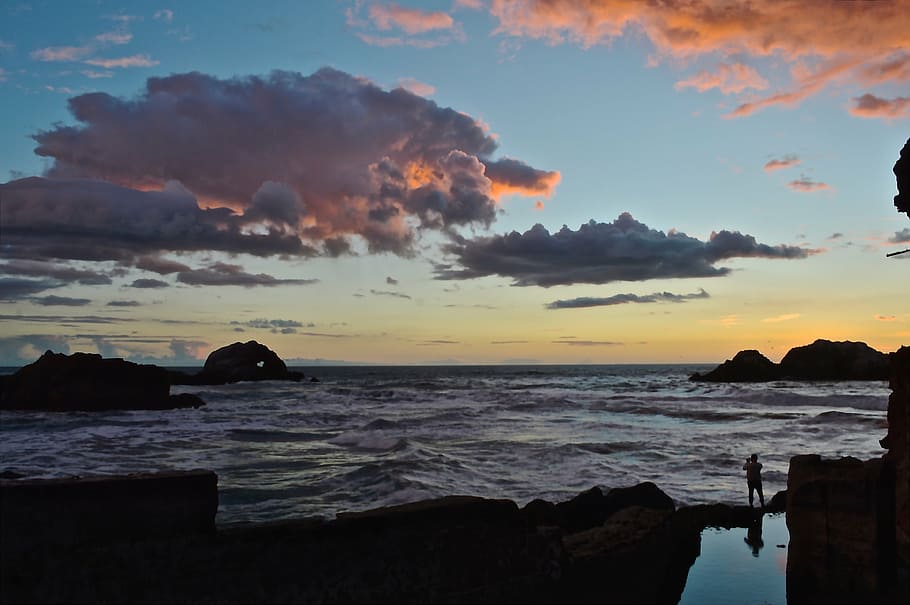 Riba, salvatge, onades, Costa, persona, oceà, mar, aigua, naturalesa, posta de sol, cel, estiu, escènic, tarda, roques, illa, escarpat, núvol - cel, bellesa a la natura, rock, escenics - natura, platja, sòlid, rock - object, silueta, terra, tranquil·litat, escena tranquil·la, color taronja, idíl·lic, cap gent, horitzó sobre l’aigua, a l'aire lliure, pila de roca, 4K