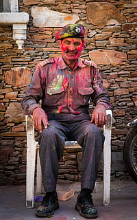 home, guàrdia, seguretat, festiu, holi, colors, cara, homes, professió, feina, segur, professional, tutor, la policia, vestit, oficial, protegir, control, uniforme, guardaespatlles, masculí, només homes, un sol home, assegut, una persona, només adults, retrat, vista frontal, adult, gent, paret de maó, mirant la càmera, longitud completa, somrient, ocupació, seient, persones reals, roba, emoció, mascles, barret, maó, relaxació, 5K, CC0, domini públic, lliure de regalies