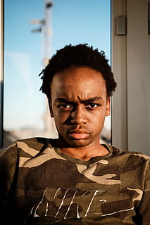 mand, iført, nike camouflage t-shirt, Brun, nike skjorte, ansigt, vred, emotion, ekspression, agterstavn, portræt, alvorlig, han-, fyr, ulykkelig, uimponeret, afro, sort dreng, dreng, teenager, milenial, hovedskud, ked, kigger på kameraet, en person, forfra, rigtige mennesker, dag, taljen op, livsstil, tæt på, tøj, ung voksen, krøllet hår, indendørs, unge mænd, arkitektur, hår, fokus på forgrunden, herrer, uniform, frisure, teenage drenge, regering, 5K, CC0, offentligt domæne, royaltyfrie