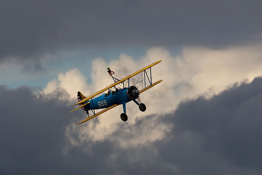 biplan, flyvende, propel, oldtimer, tung sky, luftfartøj, transportmidler, transportform, himmel, fly, Midt i luften, sky - himmel, på farten, bevægelse, lav vinkel visning, natur, rejse, ingen mennesker, udendørs, dag, helikopter, hastighed, overskyet, luftfartsindustrien, lodsning, 2K