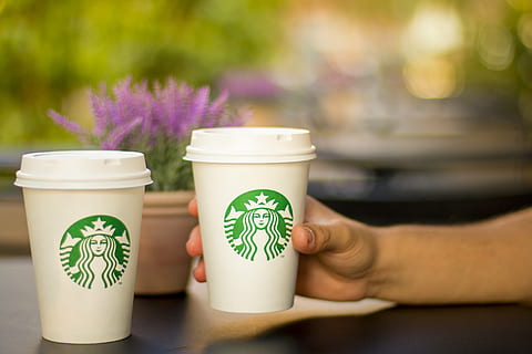 persona, celebració, starbucks, d'un sol ús, tassa, taula, cafè, cafeteria, beure, bokeh, estil de vida, begudes, cafè - beguda, tassa de cafè, cafeïna, part del cos humà, mà, mà humana, centrar-se en primer pla, menjar i beguda, planta, naturalesa, primer pla, adult, gent, flor, dia, a l'aire lliure, porpra, tassa de te, 5K, CC0, domini públic, lliure de regalies