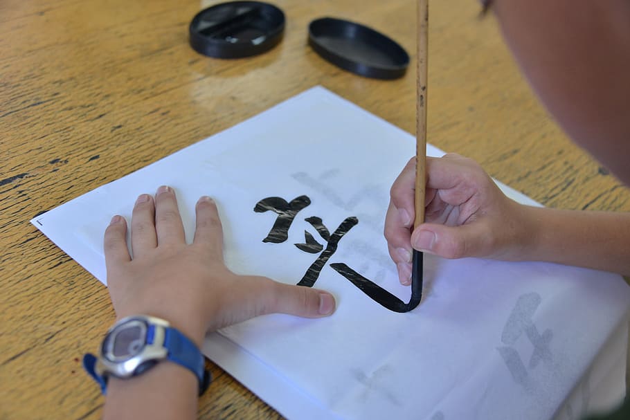 escriure, escriptura de raspall, cal·ligrafia, mà humana, mà, part del cos humà, a l'interior, taula, vista d’angle alt, creativitat, art i artesania, celebració, paper, dues persones, part del cos, descendència, infància, nen, raspall, gent, adult, dit humà, dit, 5K
