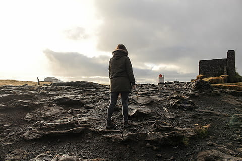 person, standing, ground, black, white, buildings, daytime, people, man, rocks, jacket, clouds, sky, alone, fashion, rear view, one person, one woman only, only women, full length, adults only, beach, adult, cloud - sky, real people, nature, lifestyles, land, leisure activity, architecture, men, solid, rock - object, rock, day, outdoors, warm clothing, 5K